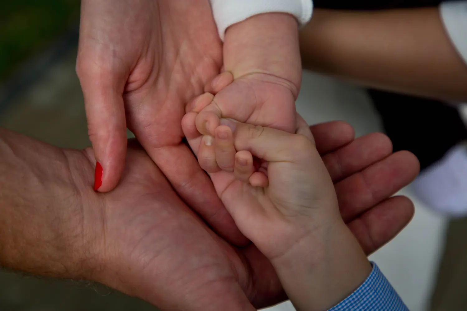 Voksne hender og en babyhånd holder hverandre, symboliserer å beskytte dem som er avhengige av deg